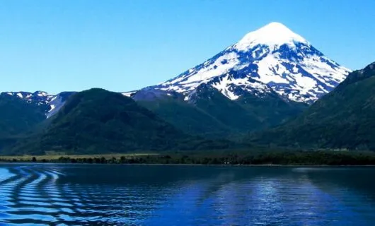 Mountain peak rises over rippling lake