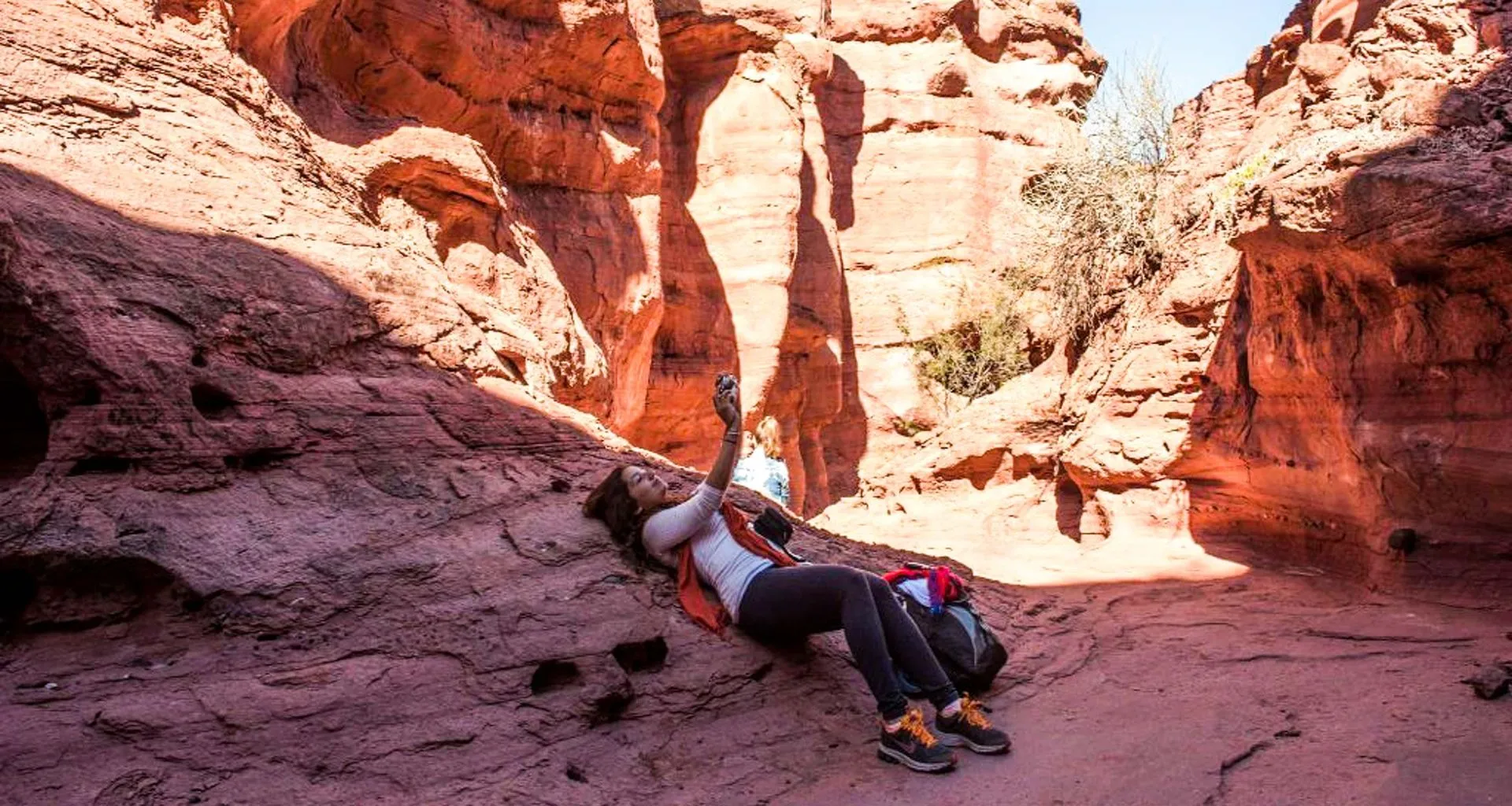 Woman lies on rock in canyon