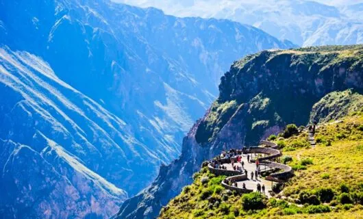 Travelers look at valley from viewing platform near Machu Picchu
