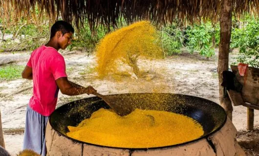 Man mixes cornmeal in large metal basin