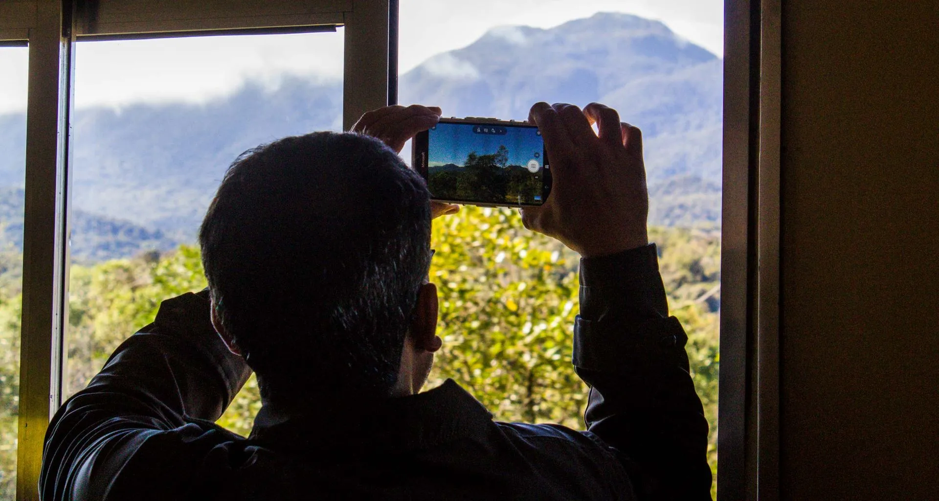 Man takes picture of mountain through phone
