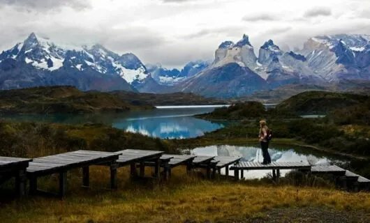 Traveler stands on walkway near Patagonia lake