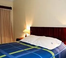 bed with blue and green bedding in hotel room