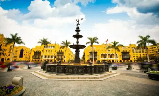 Yellow buildings surrounding Peru fountain plaza