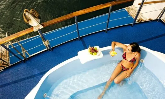 Woman lounges in pool on deck of cruise ship