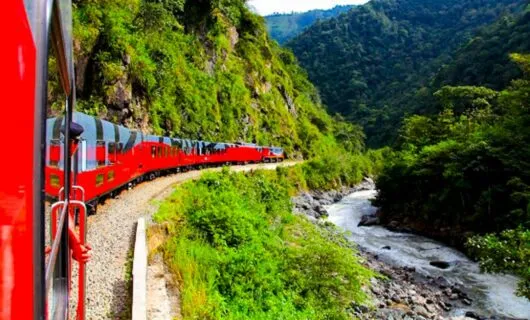 Red train runs through Andes valley