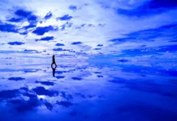 Person walking across reflective salt flats