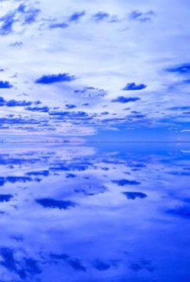 Person walking across reflective salt flats on a Bolivia tour