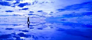 Person walking across reflective salt flats on a Bolivia tour