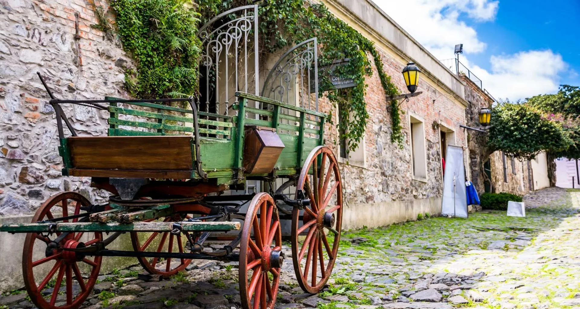 Wagon parked against stone wall on cobblestone road