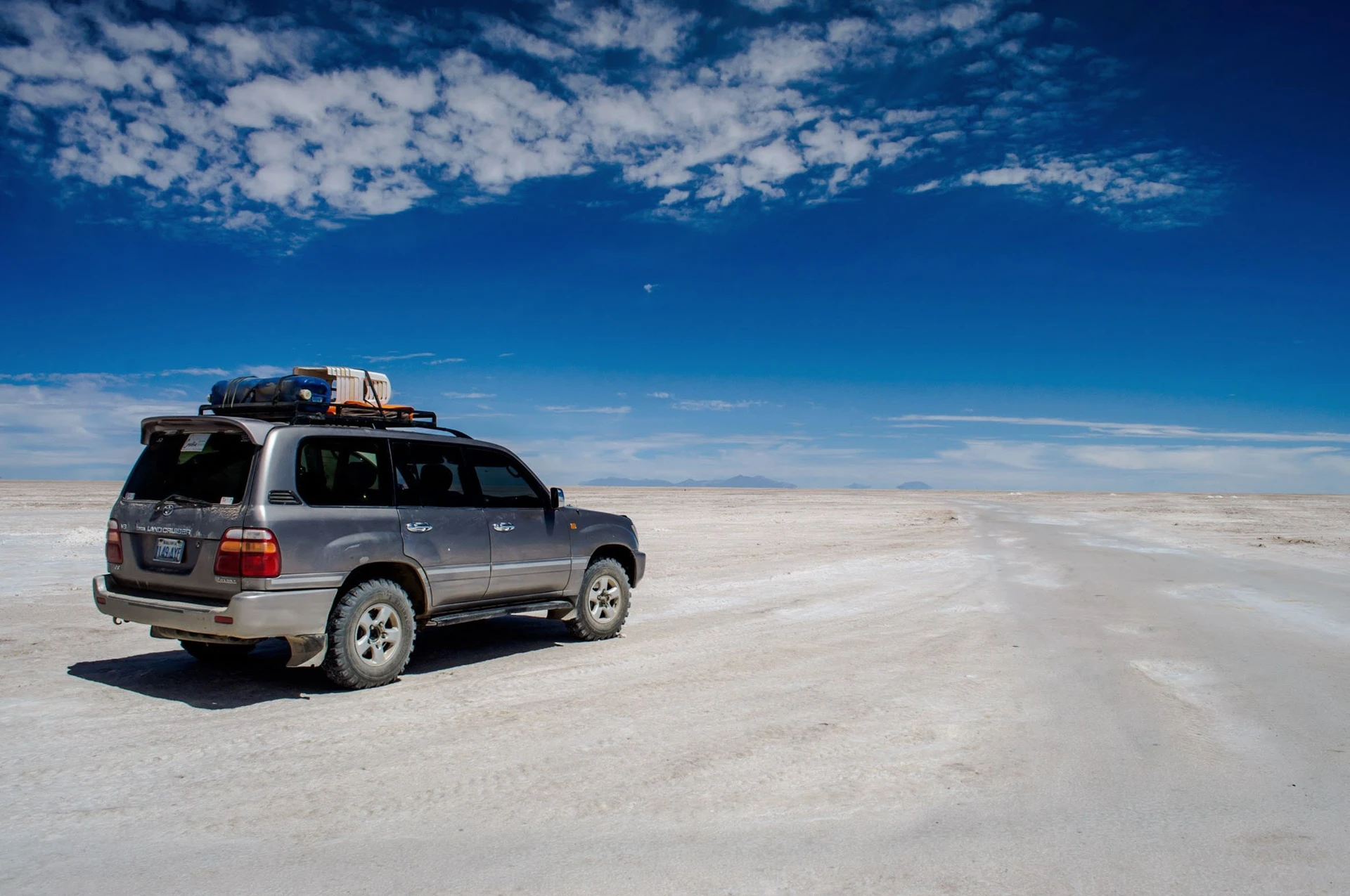 SUV drives across salt flats of Bolivia