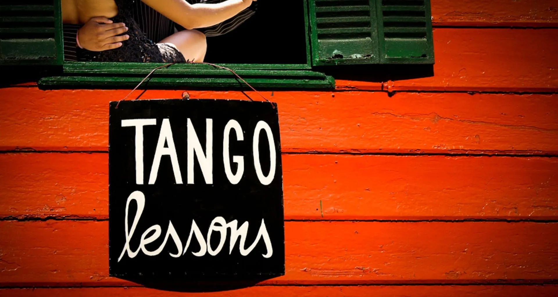 Tango lessons sign hands on red building