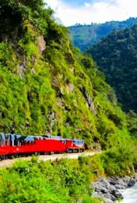 Red train travels through mountain valley