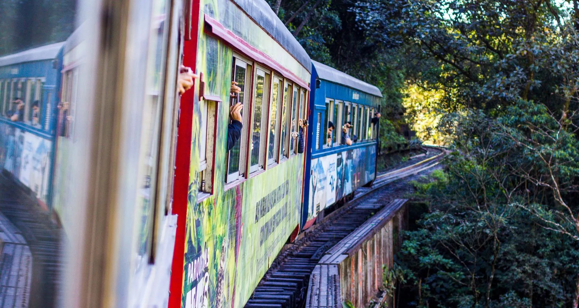 Travelers wave and take pictures out window of train