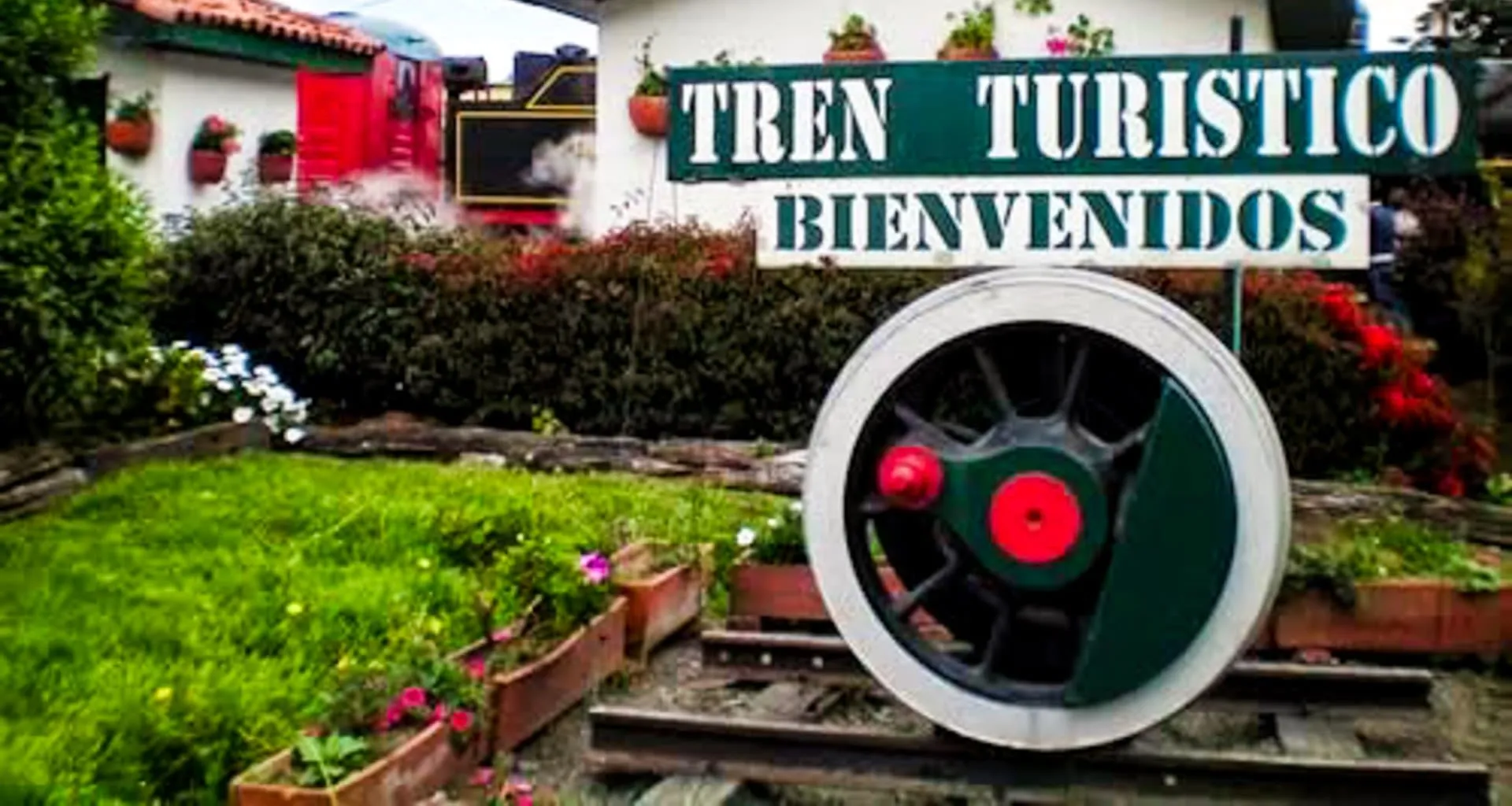 "Tren Turistico Bienvidos" sign above train wheel