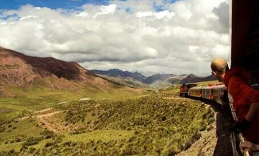 Man leans out window of South America train