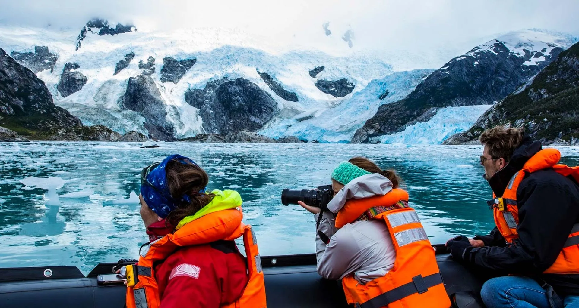 Travelers on cruise ship take pictures of mountains