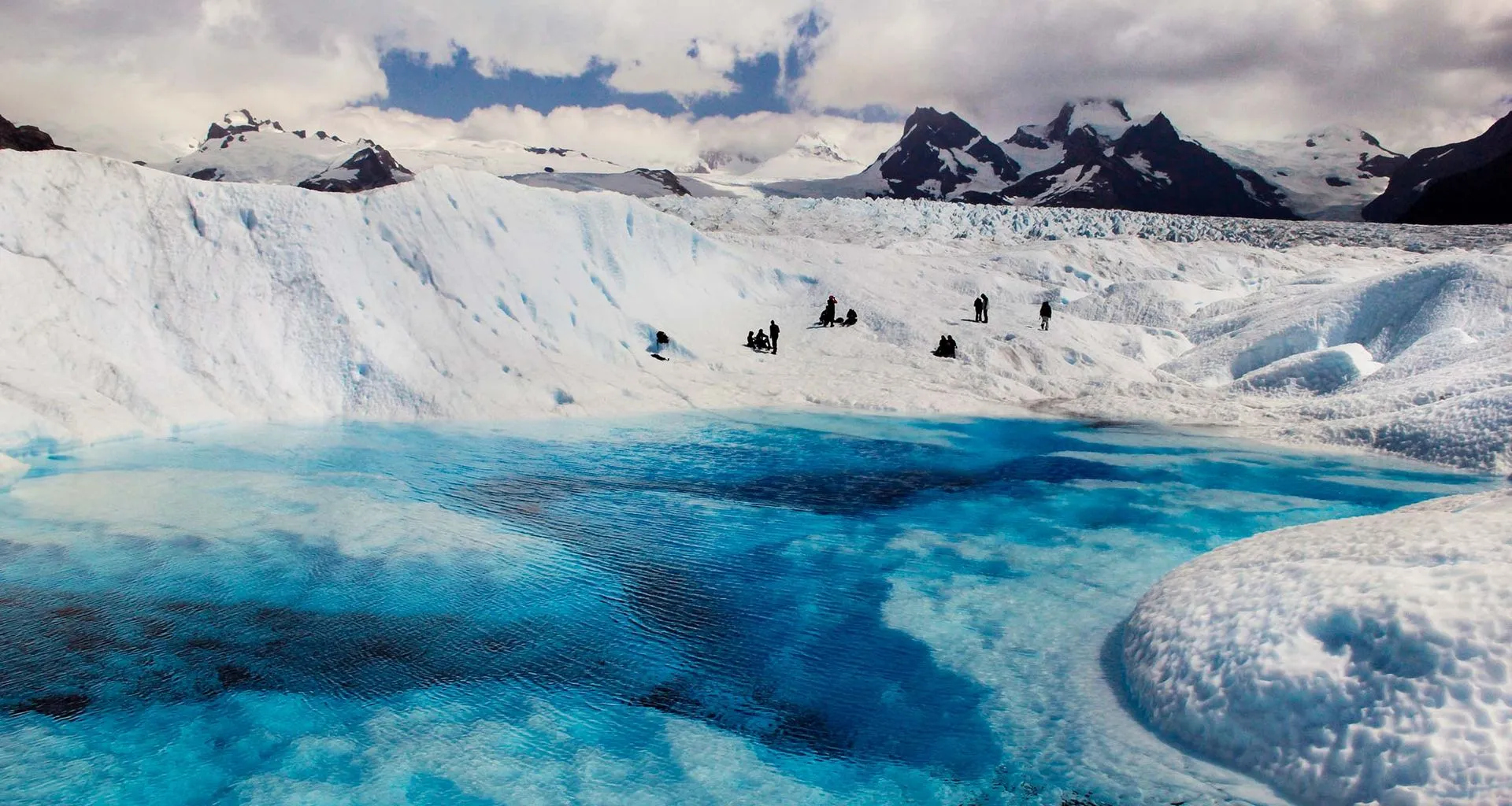 Travelers on shore of icy lake