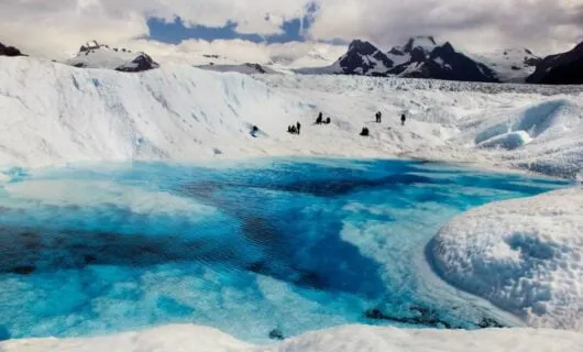 Travelers on shore of icy lake