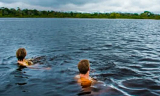 Travelers swim in Amazon river