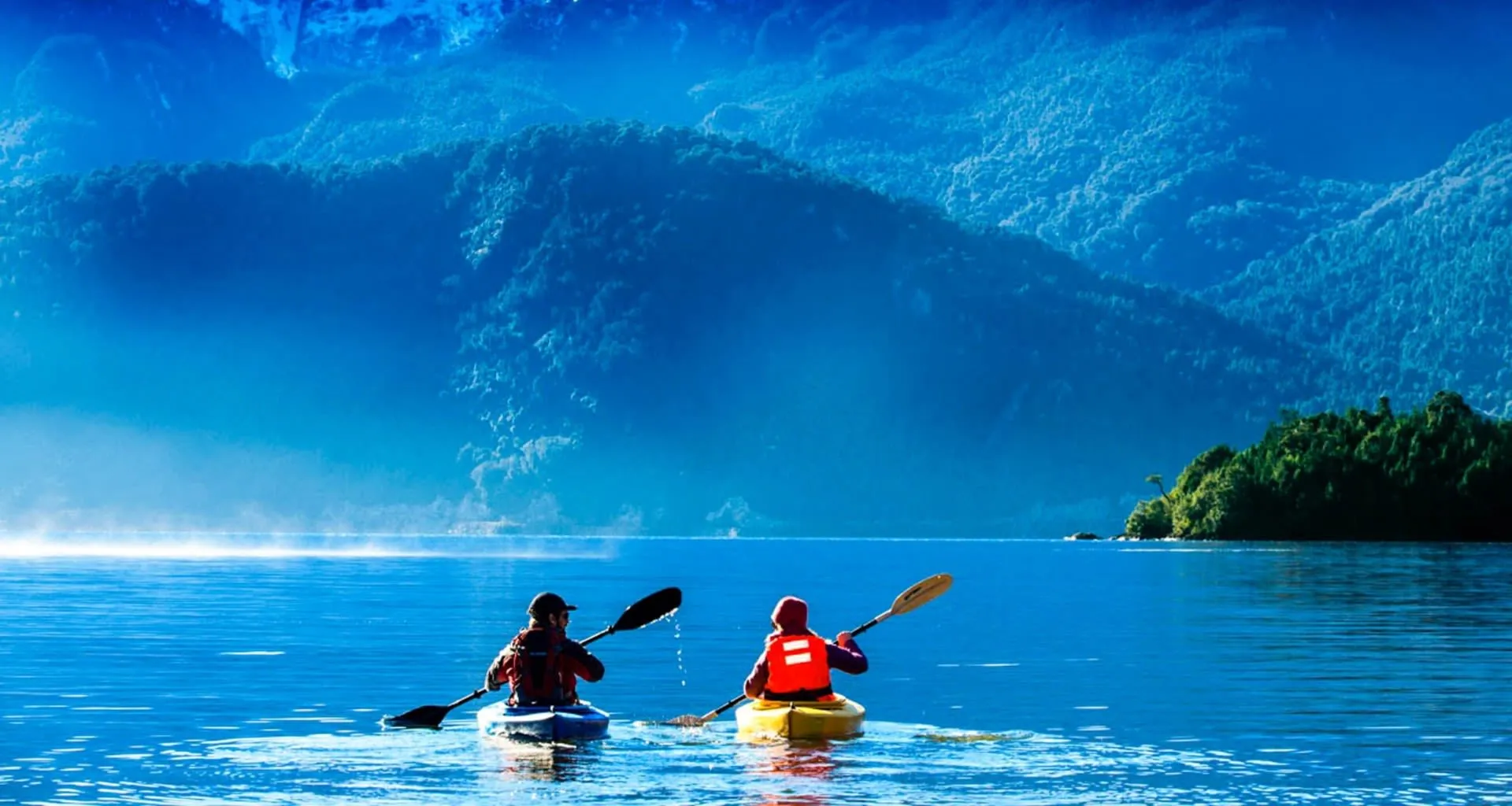 Two kayakers on mountain lake