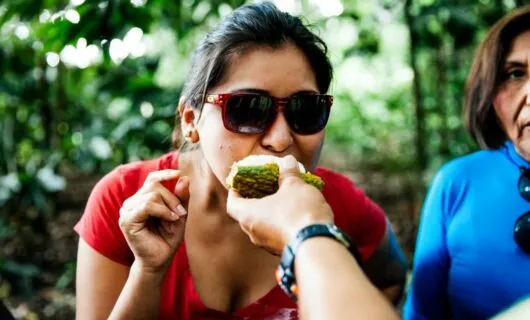 Woman leads in to take a bite of fruit