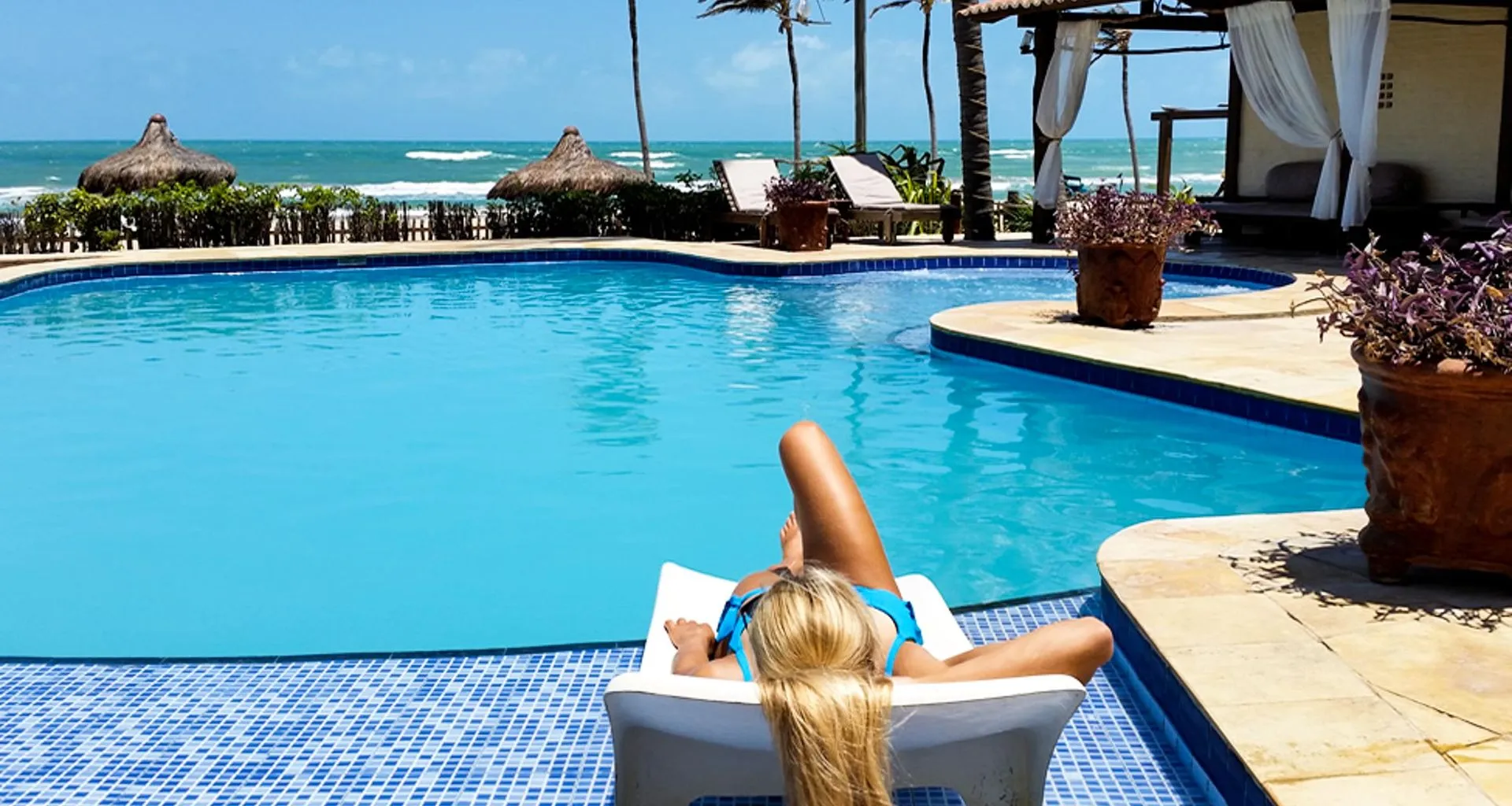 Woman relaxes by resort pool