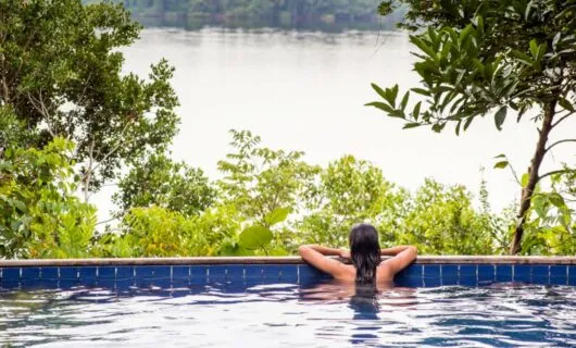 Woman sits at edge of Anavilhanas Jungle Lodge pool
