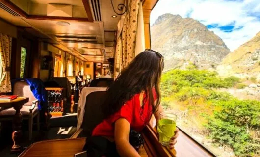 Woman enjoying drink and views on vintage train