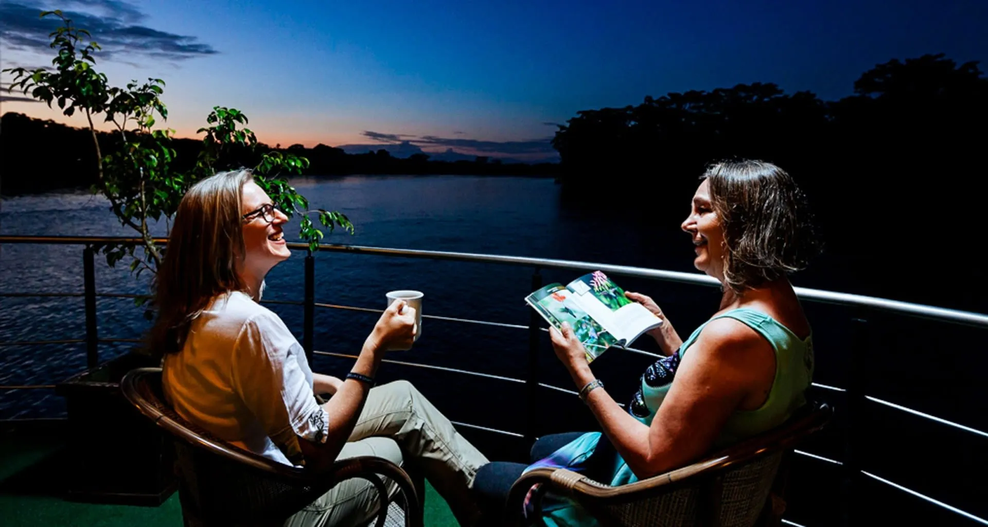 Women sit on cruise ship deck at night