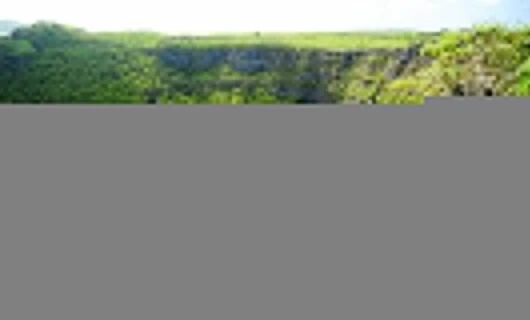 Traveler sits at edge of valley cliff