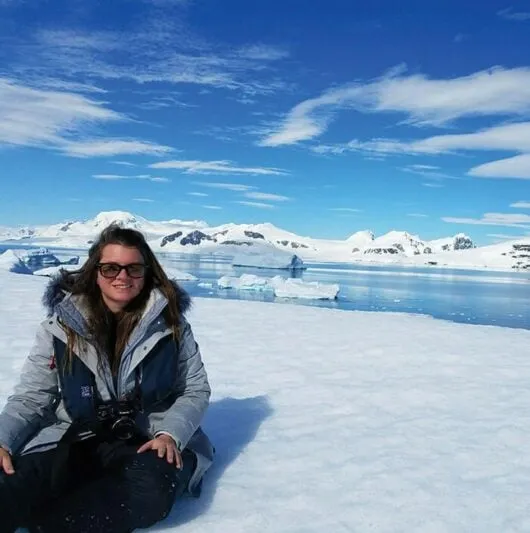 woman sitting in the snow in antarctica