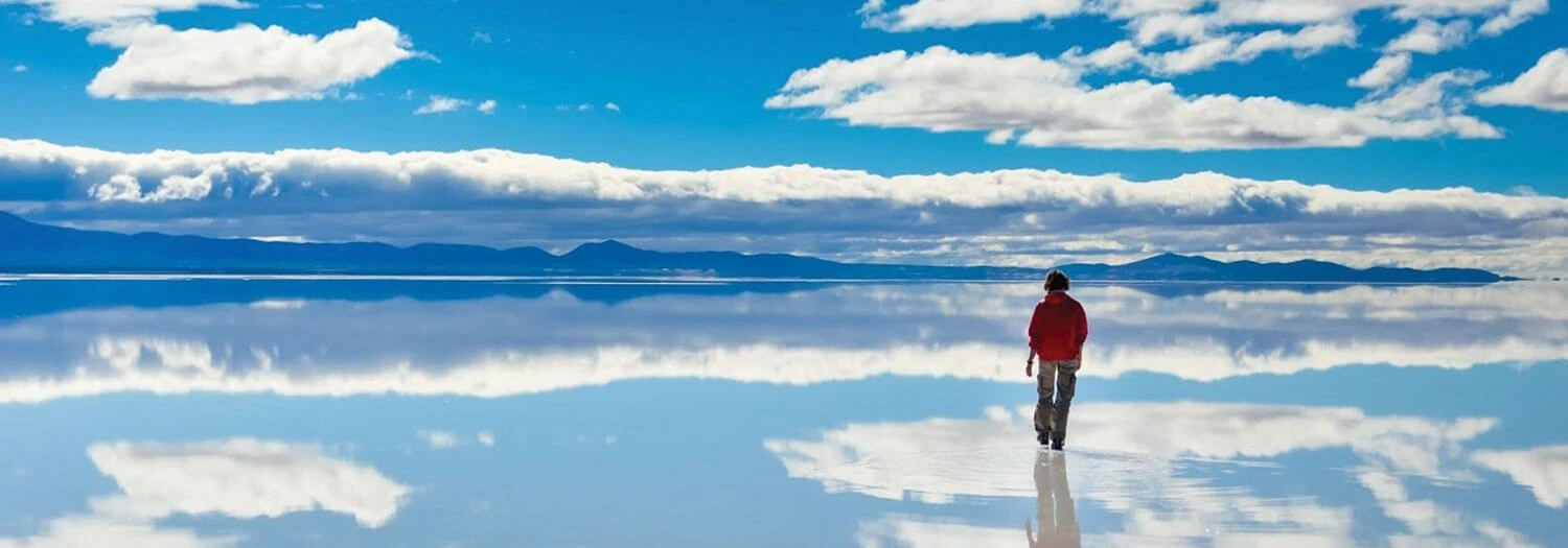 traveler walking on the Uyuni Salt Flats during Bolivia's summer