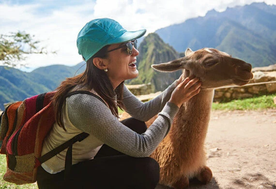 woman petting a llama at machu picchu peru