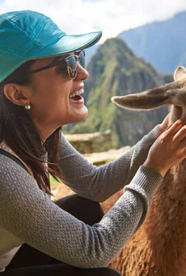 woman at Machu Picchu petting a llama