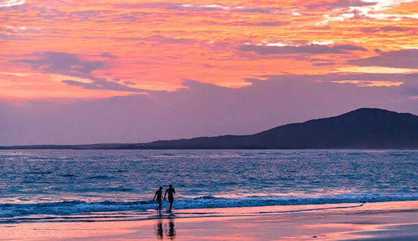 couple walking on the beach at sunset on the galapagos
