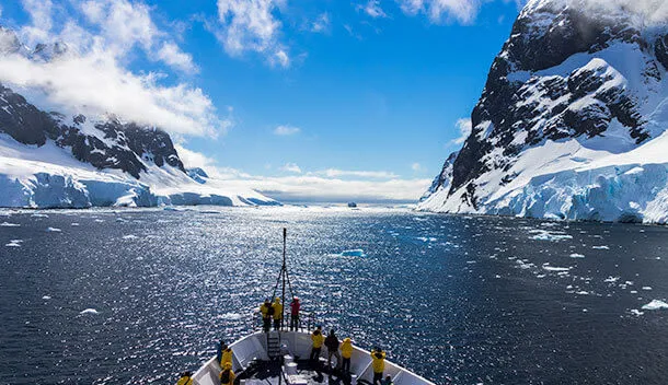 ship entering antarctica with glaciers on both sides