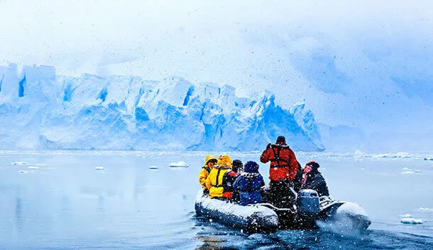 travelers on a snowy zodiac excursion in antarctica